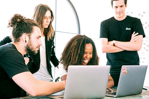 Symbolbild zum EU-Talentpool: Vier junge Menschen arbeiten gemeinsam an Laptops in einem modernen, hellen Büro | Sabine Verheyen
